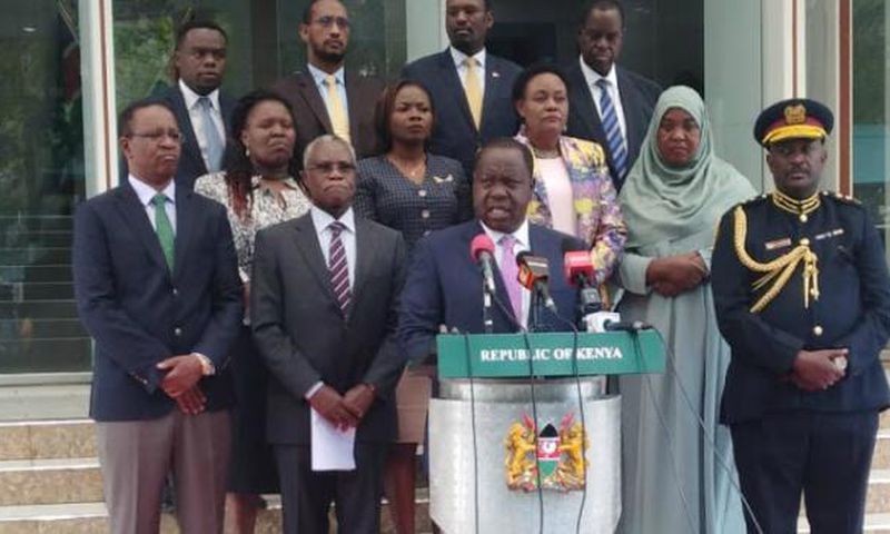 Interior CS Fred Matiang'i, Inspector General Hillary Mutyambai and NCIC led by Chairman Samuel Kobia addressing the media at Harambee House. Fatuma (standing behind Hillary Mutyambai) passed on Sunday, December 29 after collapsing at a wedding