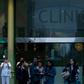 People walk outside the Hospital Clinic in Barcelona on February 25, 2020 where a woman was hospitalised in a suspected case of coronavirus
