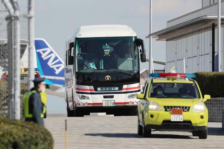 Japanese evacuees are transported by bus after they arrived back in Tokyo from Wuhan