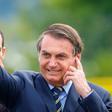 Brazilian President Jair Bolsonaro waves as he arrives for the hoisting of the national flag ceremony outside the Alvorada Palace in Brasilia, on January 21, 2020