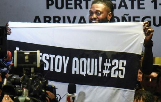 Togo forward Emmanuel Adebayor holds up a message to his new fans at Paraguay champions Olimpia on his arrival in Asuncion