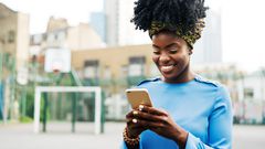 Woman using smart phone in city