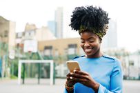 Woman using smart phone in city