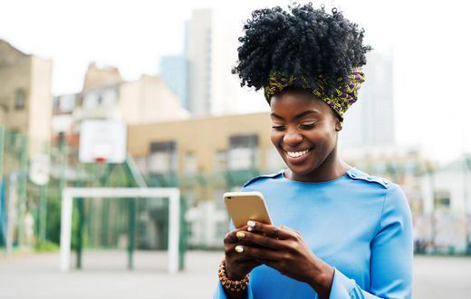 Woman using smart phone in city
