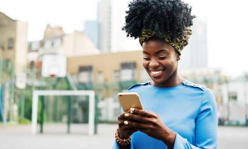 Woman using smart phone in city