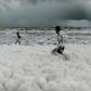 Children have been playing and taking selfies in the clouds of white suds on Marina Beach, even though they give off an acrid smell and fishermen have been told not to go into the sea nearby
