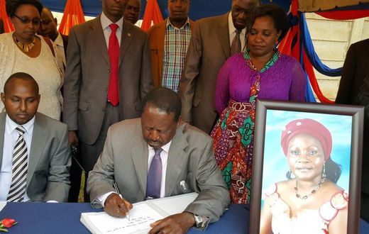 File image of Raila Odinga signing a condolence book He is among national leaders who has mourned Achieng Oneko's widow