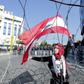 A Lebanese demonstrator waves the national flag while security forces stand by