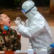 A medical worker takes a swab for testing from a Chinese paramilitary police officer in Shenzhen, Guangdong province
