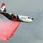 A C-130 Hercules plane from the New South Wales Rural Fire Service dropping fire retardent on bushfires