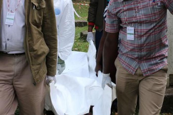 Police carrying a dead body from a crime scene