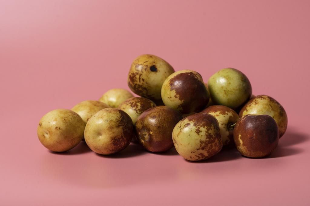 Red jujubes on pink background