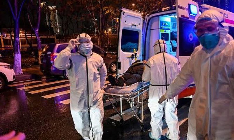 Medics handle an infected patient. Ambassador Sarah Serem cancels leave to return to her post in  China amid Coronavirus crisis