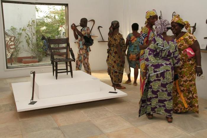 Visitors contemplate artefacts recently returned to Benin and on show at Cotonou's "Petite Musée de la Recade