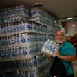 A man smiles after finding bottled water on sale in a liquor store in  Rio de Janeiro on January 15, 2020