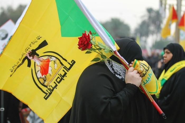 A supporter holding the flag of Hezbollah, which the UK government designated as a terror organisation