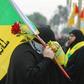 A supporter holding the flag of Hezbollah, which the UK government designated as a terror organisation