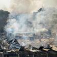 Smoke rises over the debris of a building that collapsed during a fire in New Delhi