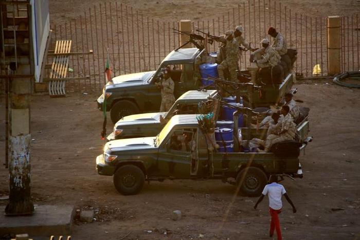 Members of Sudan's intelligence services shoot bullets in the air at the headquarters of the Directorate of General Intelligence Service in the Riyadh district of the capital Khartoum