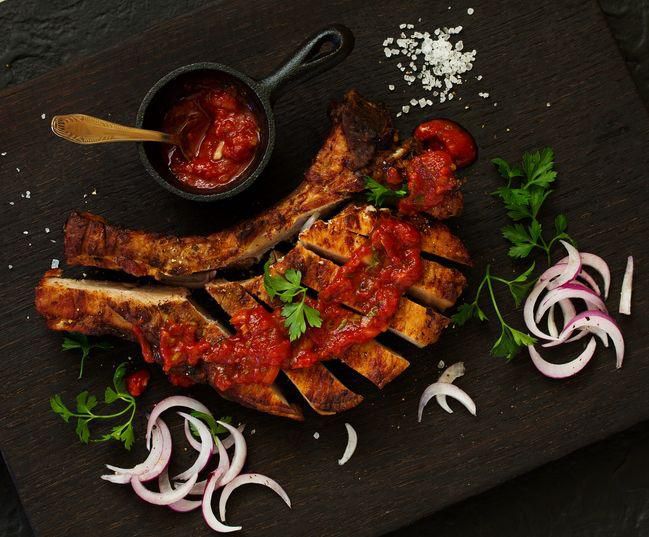 Pork chop on the bone with tomato sauce. view from above.