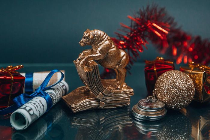 Shiny golden bull figurine and bauble arranged with money during New Year holiday (Photo: Victoria Emerson)