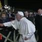 A frame grab taken from a handout video made available by Vatican Media on January 1, 2020 shows a lady (L) grabbing at Pope Francis's hands as he greets Catholic faithful as he arrives to celebrate New Year's Eve mass in Vatican City