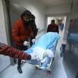 Emergency personnel pull a gurney with a victim on it from an air strike on a military school in the capital Tripoli