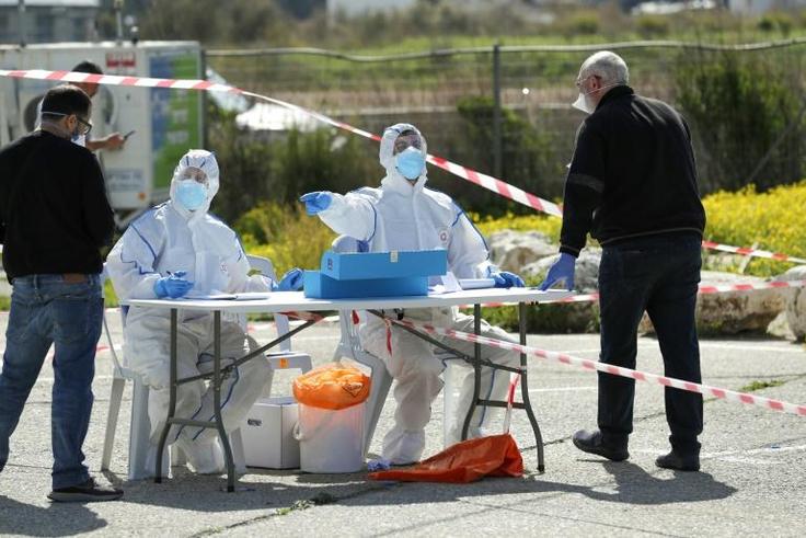 Israelis vote at a polling booth specially erected for the 5,600 voters under quarantine, many of whom visited countries where the coronavirus COVID-19 is prevalent