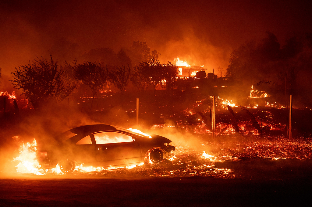 <strong>VEHICLES AND</strong> homes burned as the fire tore through Paradise.