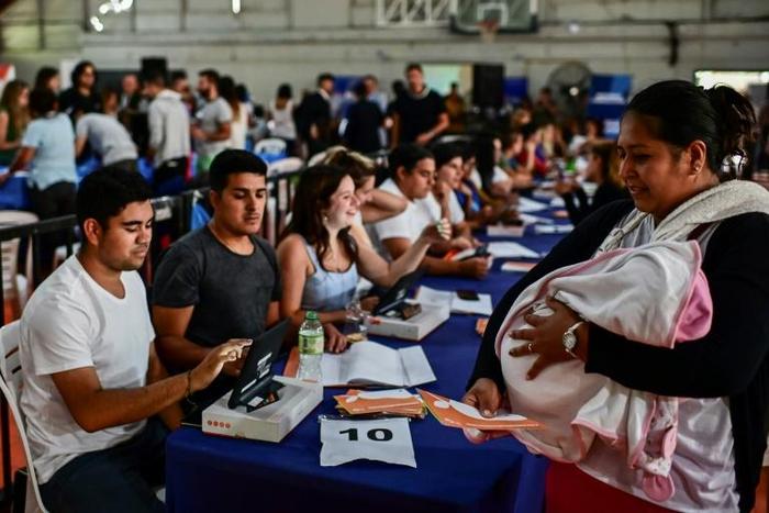 A woman with a baby collects a government-issued food card in Lomas de Zamora, close to the capital Buenos Aires