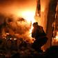 A volunteer firefighter battles a blaze after a night-time air strike on the Idlib province town of Ariha