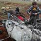 Syrians inspect the wreckage of a regime military helicopter after it was brought down over western Aleppo province