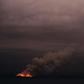 This handout photo taken on January 6, 2020 and received on January 7 from the Australian Department of Defence shows a fire in the distance seen from the Royal Australian Navy's HMAS Adelaide ship off the coast in Eden in New South Wales