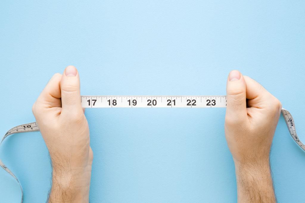 Man's hands holding white measure tape on pastel blue background. Mock up for body slimming, weight loss or dressmaker's offer or other ideas. Closeup. Point of view shot. Empty place for text. Top view.