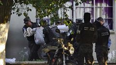 Honduran military police carry the body of a colleague after the escape of MS-13 gang leader Alexander Mendoza on February 13, 2020