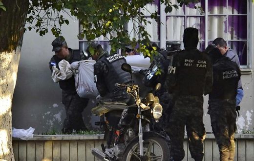 Honduran military police carry the body of a colleague after the escape of MS-13 gang leader Alexander Mendoza on February 13, 2020