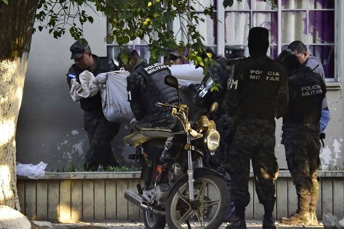 Honduran military police carry the body of a colleague after the escape of MS-13 gang leader Alexander Mendoza on February 13, 2020