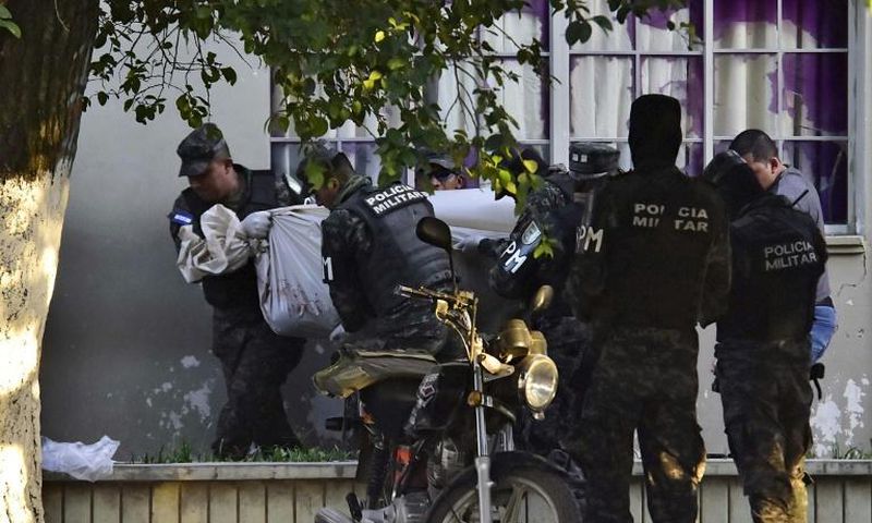 Honduran military police carry the body of a colleague after the escape of MS-13 gang leader Alexander Mendoza on February 13, 2020