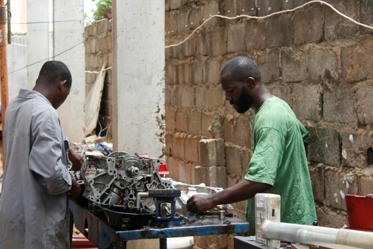 Mechanic Joao Pande, right, says corruption still permeated all levels of Angolan society. "If you know someone... they will do what you want and then you pay"