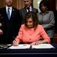 US House Speaker Nancy Pelosi signs the articles of impeachment against President Donald Trump