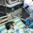 This photo taken on January 24, 2020 and released by China's Xinhua News Agency shows chief nurse Ma Jing (R) holding a patient's hand to comfort her in the ICU (intensive care unit) of Zhongnan Hospital of Wuhan University in Wuhan