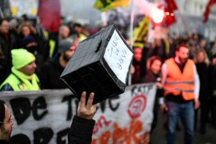 Multiple funds have been launched to help compensate striking workers. The picture shows a marcher holding up a contribution box