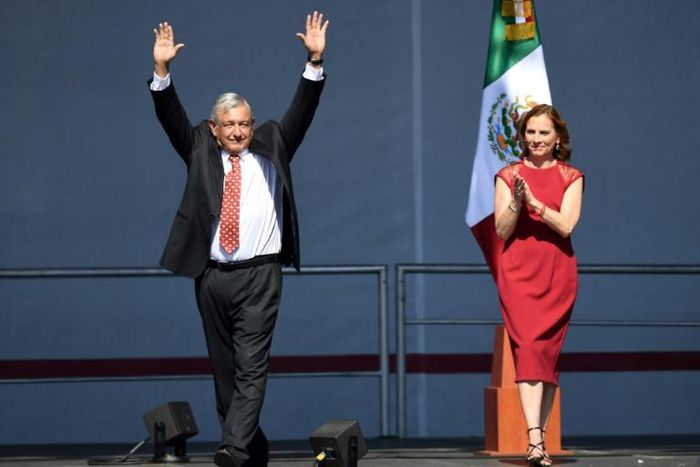 Mexican President Andres Manuel Lopez Obrador (left) waves next to his wife Beatriz Gutierrez Muller during a rally marking his first year in office at the Zocalo square in Mexico City on December 1, 2019