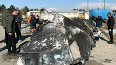 People analyze the fragments and remains of the Ukraine International Airlines plane that crashed outside Tehran