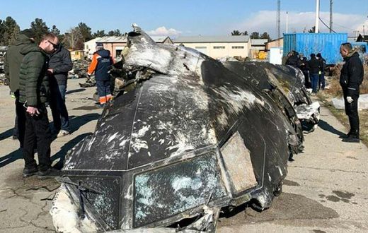 People analyze the fragments and remains of the Ukraine International Airlines plane that crashed outside Tehran