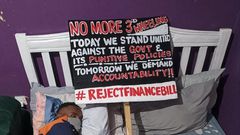 A protestor lies next to his placard during the anti-Finance Bill protests led by Gen Z on June 25, 2024, in Nairobi.