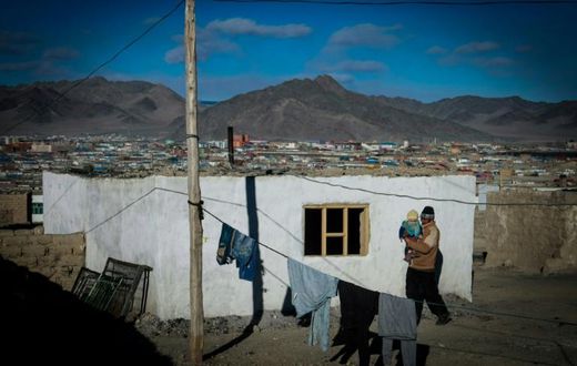 A man carries a child in the center of Bayan-Ulgii, a province of Mongolia bordering Russia and China  which has seen two bubonic plague cases