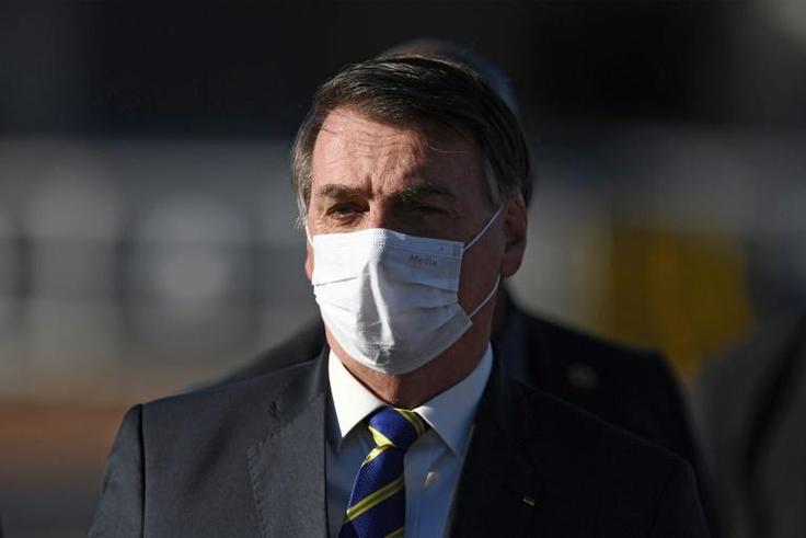 Brazilian President Jair Bolsonaro wears a face mask as he arrives at a flag-raising ceremony at the Alvorada Palace in Brasilia, Brazil, on May 12, 2020