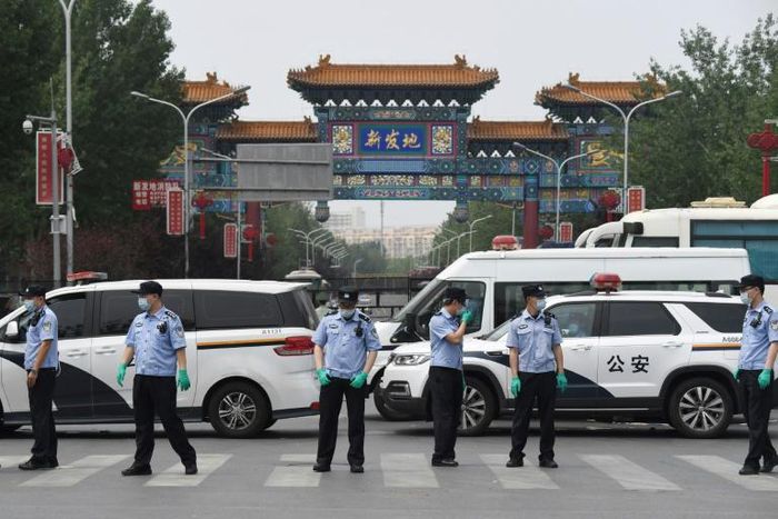 Police guard a Beijing market linked to a new coronavirus cluster