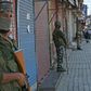 Indian paramilitary troops stand guard in front of closed shops in Srinagar